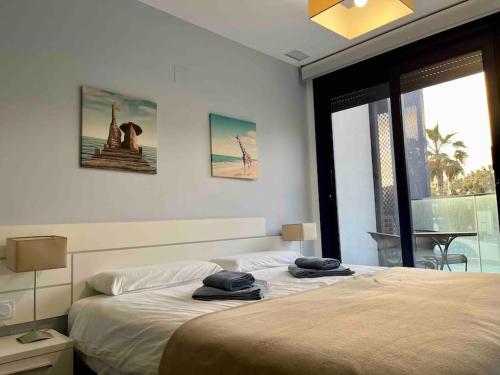 um quarto com uma cama com duas toalhas em Perfect Ground Floor with Sea View em Punta Prima