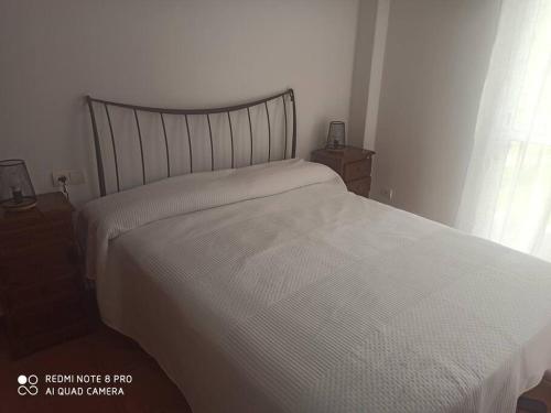 sypialnia z łóżkiem z białą kołdrą w obiekcie Unifamiliar 3 dormitorios Casa Mar w mieście Islantilla