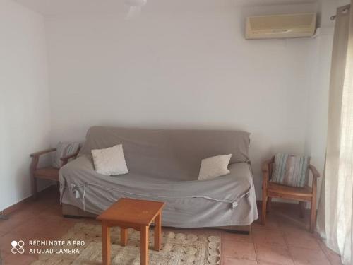 ein Sofa im Wohnzimmer mit 2 Stühlen und einem Tisch in der Unterkunft Unifamiliar 3 dormitorios Casa Mar in Islantilla