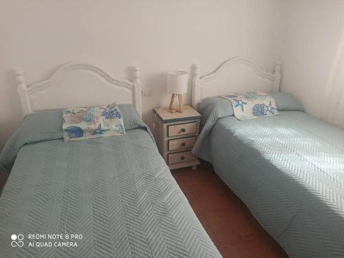 dwa łóżka siedzące obok siebie w sypialni w obiekcie Unifamiliar 3 dormitorios Casa Mar w mieście Islantilla