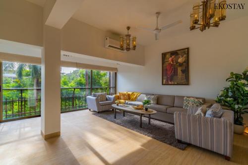 sala de estar con sofá y mesa en EKOSTAY Luxe - Casa Marina, en Candolim