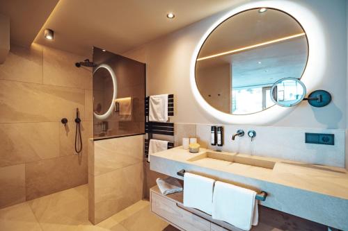 a bathroom with a sink and a mirror at Hotel Plan de Gralba - das Berghotel in Selva di Val Gardena