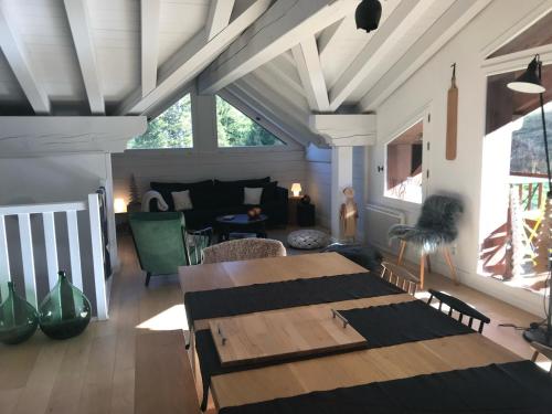 a living room with a table and a couch at les 7 laux immobilier chalet D in Prapoutel
