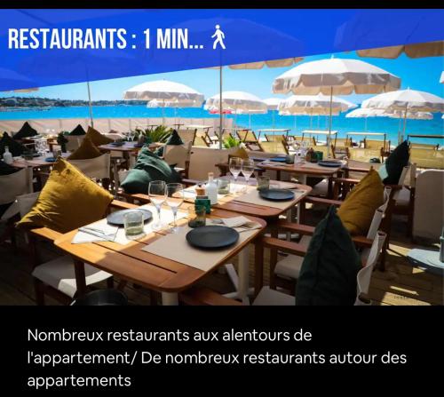 un restaurant avec tables et parasols sur la plage dans l'établissement Impeccable 3 pièces avec balcons, la plage à 50m Juan les pins proche Cannes, à Antibes