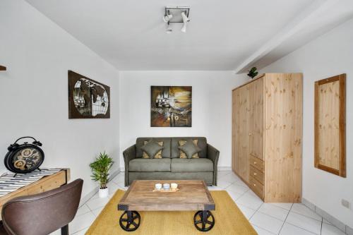 ein Wohnzimmer mit einem Sofa und einem Tisch in der Unterkunft Chic studio dans l'hypercentre parisien in Paris