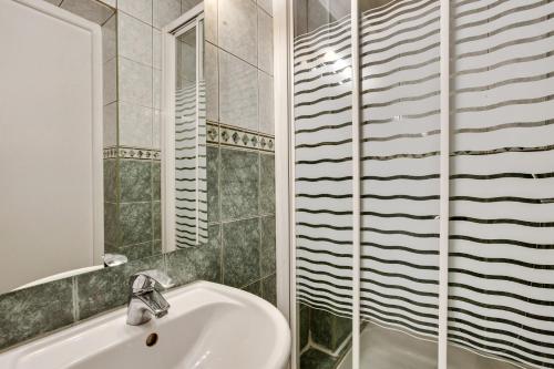 ein Bad mit einem Waschbecken und einem Spiegel in der Unterkunft Chic studio dans l'hypercentre parisien in Paris