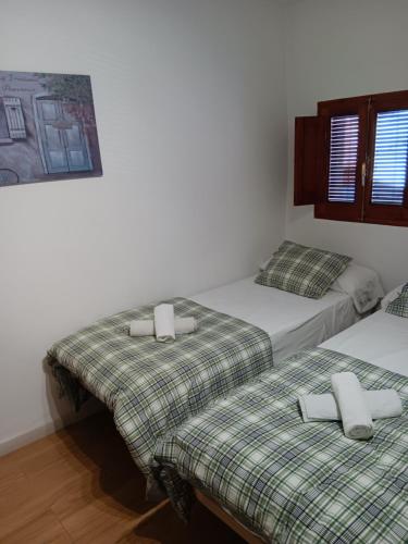 two beds sitting next to each other in a room at EL RINCÓN deMANUELA in Requena