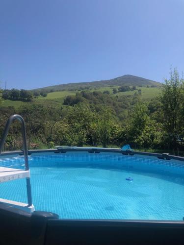 a large swimming pool with mountains in the background at Un écrin dans la nature in Espelette