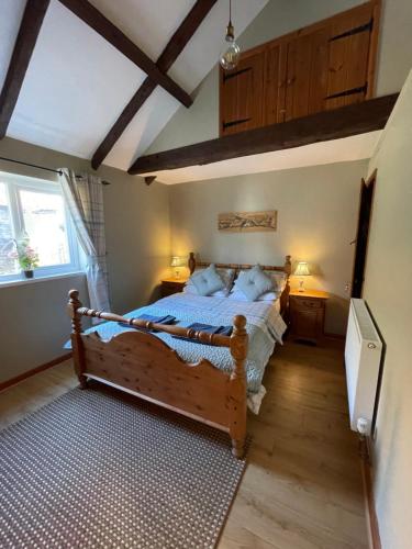 a bedroom with a wooden bed in a room at The Dairy Scratby in Scratby
