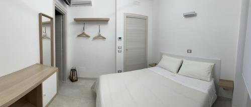 a white bedroom with a white bed in a room at Perla Saracena in Lucera