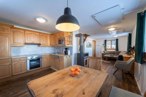 eine Küche mit einem Holztisch mit Orangen darauf in der Unterkunft Almhütte Hebalm mit Whirpool in Pack