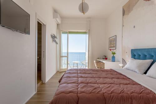 een slaapkamer met een groot bed en een groot raam bij Cas’ A Mare - Beachfront Luxury Suites in Salerno