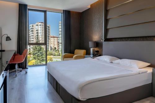 a bedroom with a large bed and a large window at Park Dedeman Eskişehir in Eskisehir