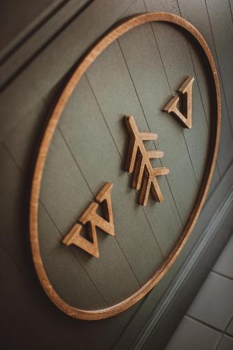 a mirror with three wooden signs on a wall at Wooden Villa APARTMENTS in Jūrmala