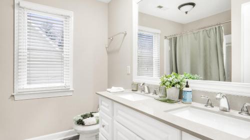 a white bathroom with a sink and a toilet at 4-bedroom Bliss With Downtown Proximity in Greensboro