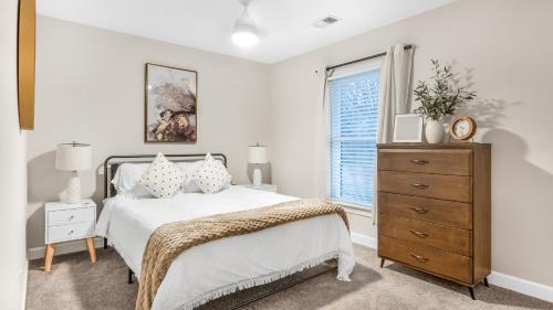 格林斯伯勒的住宿－4-bedroom Bliss With Downtown Proximity，一间卧室配有一张床、一个梳妆台和一扇窗户。