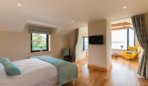 een slaapkamer met een bed en een woonkamer bij Luxury 4 bedroom holiday home overlooking the sea on Valentia Island in Knights Town