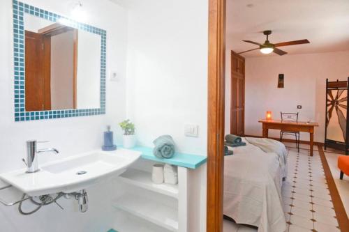 ein Bad mit einem Waschbecken und ein Bett in einem Zimmer in der Unterkunft Casa Jenabe in La Vegueta