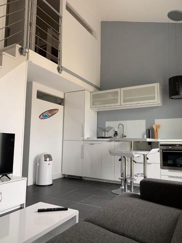 une cuisine blanche avec une table et un comptoir dans l'établissement Charmante petite maison à proximité de la plage, à Palavas-les-Flots