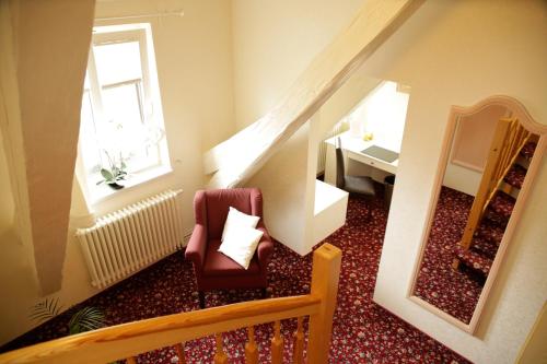 a living room with a chair and a mirror at Ringhotel Schloss Tangermünde in Tangermünde
