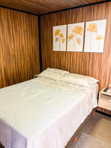 uma cama num quarto com três fotografias na parede em Cabana Vista Bela em São Salvador