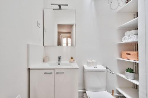 a white bathroom with a sink and a toilet at Wonderful Studio at Place de la Bastille in Paris