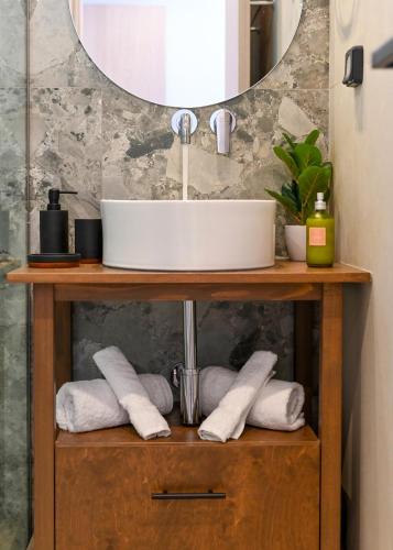 a bathroom sink on a wooden stand with towels at Nemesis Villas in Plakias
