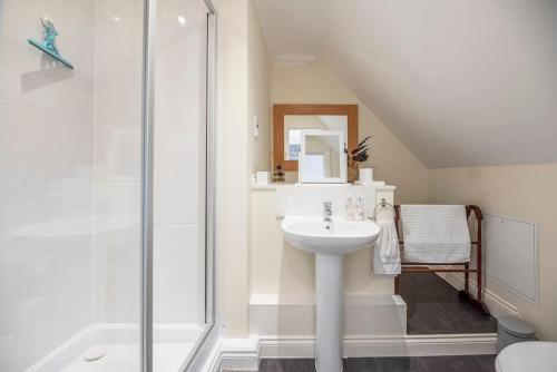 a bathroom with a sink and a shower at Fromus Rise, Saxmundham in Saxmundham