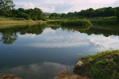 a river with a reflection of the sky in the water at Rustic River & Bush Escape in Buffelspoort