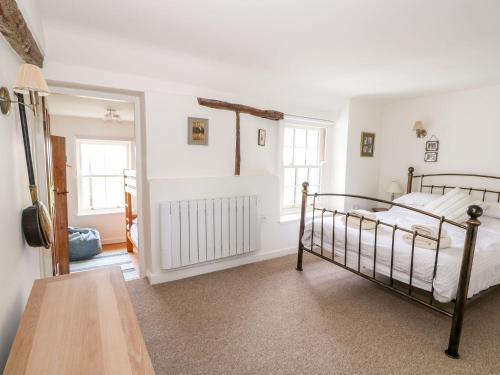a bedroom with a bed and a table at Beach Cottage in Holt