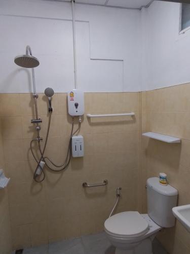 a bathroom with a toilet and a shower at The Rock Coco Villa in Ban Laem Pom