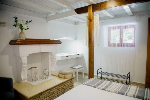 a room with a fireplace and a bed in it at YARD- Family retreat in Kórinthos