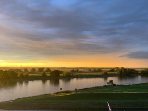 a view of a river with the sunset in the background at Ringhotel Schloss Tangermünde in Tangermünde