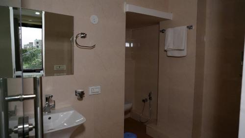 a bathroom with a sink and a shower with a mirror at Hotel Park Street in Pathānkot