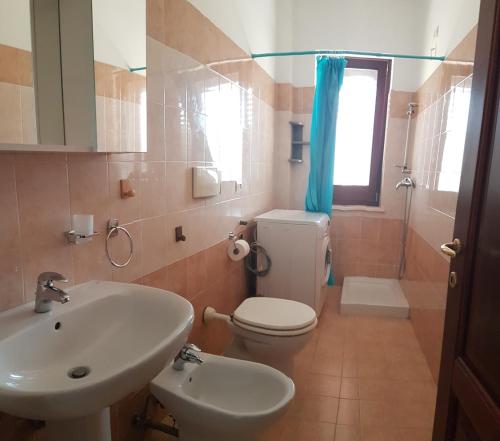 bagno con lavandino, servizi igienici e finestra di Badisco Vacanze a Otranto