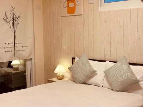 a bedroom with a bed with white sheets and pillows at The Green Mile Field B&B in Jian