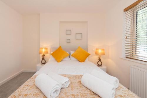 a bedroom with a large white bed with yellow pillows at 2Bedroom Flat Freeparking in Reading