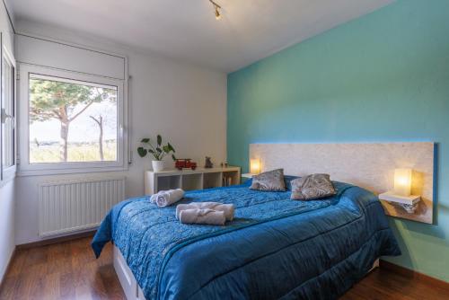 1 dormitorio con 1 cama azul y 2 toallas en Casa adosada WELCS PDA-113-con terraza, en Platja d'Aro