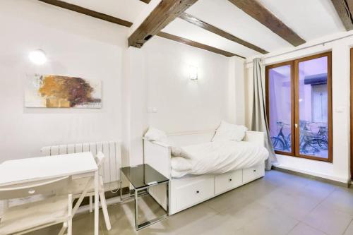 une chambre blanche avec un lit et un bureau dans l'établissement Charming studio historical center of Strasbourg, à Strasbourg