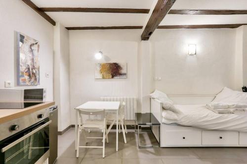 - une cuisine blanche avec un lit et une table dans l'établissement Charming studio historical center of Strasbourg, à Strasbourg