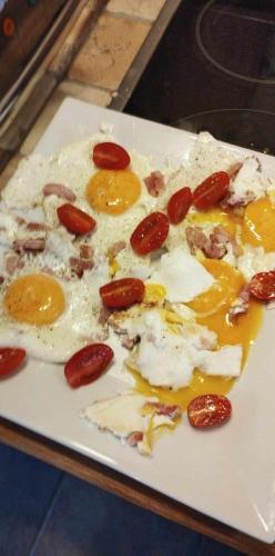 a white plate with eggs and fruit on it at Gîte du Cheval Blanc à Houmont in Sainte-Ode