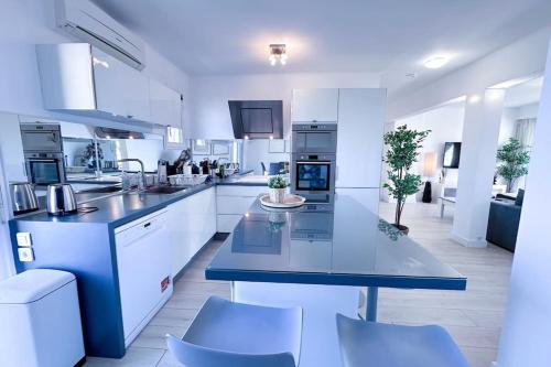 une cuisine avec des placards blancs et un comptoir bleu dans l'établissement LAVERNE - Stunning Sea View T3 with South-Facing Terrace, à Antibes