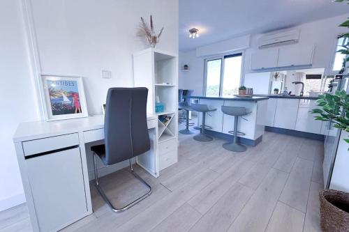 - une cuisine blanche avec un bureau et une chaise dans l'établissement LAVERNE - Stunning Sea View T3 with South-Facing Terrace, à Antibes