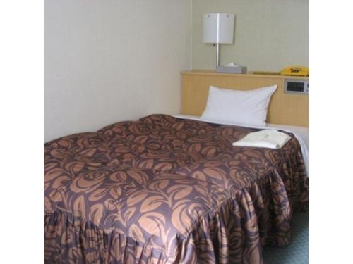 een bed in een hotelkamer met een bruine deken bij Akashi Castle Hotel - Vacation STAY 79268 in Akashi