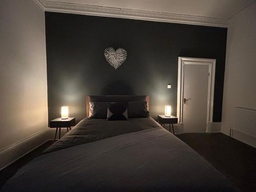a bedroom with a large bed with two lights on the wall at Myrtle Villas in Hull