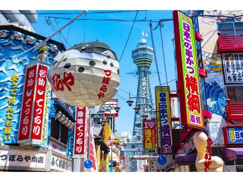 大阪市にあるHotel Aiwa for men's onlyの看板や建物が並ぶ賑やかな街道
