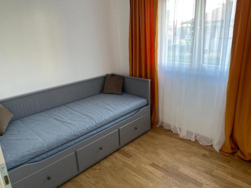 - un canapé dans l'angle d'une chambre avec fenêtre dans l'établissement Apartman Jovanov Dvor, à Bijeljina