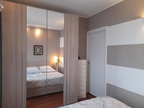 Schlafzimmer mit einem verspiegelten Schrank und einem Bett in der Unterkunft Elegant and modern Apartment "Le Fontane" Moncalieri in Moncalieri