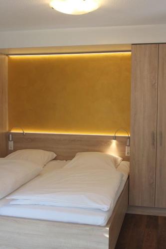 a bed with a yellow headboard in a room at Burghotel Schöne Aussicht Bauer GmbH in Winnenden