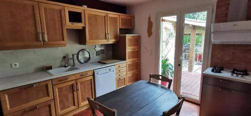 une cuisine avec une table en bois et une salle à manger dans l'établissement Villa indépendante, parc et piscine privée, ramassez vos oeufs coques, à Saint-Médard-de-Guizières